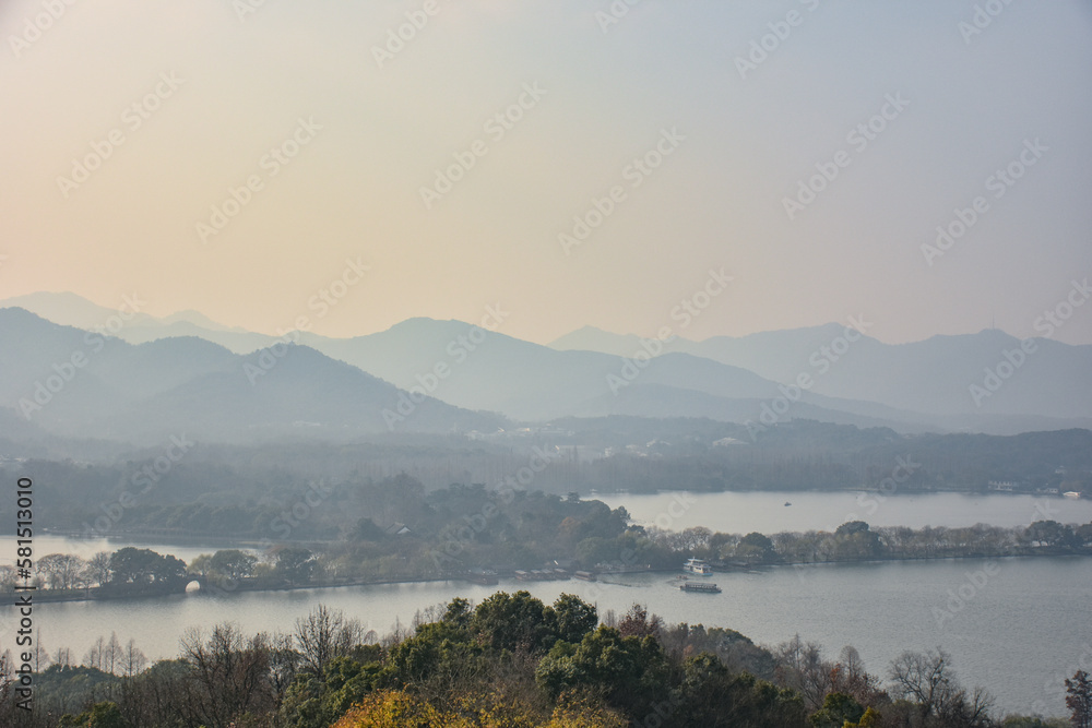High angle view of the calm seascape and mountains in the cloudy weather. Travel rural scene. West Lake. Popular park of Hangzhou city China.