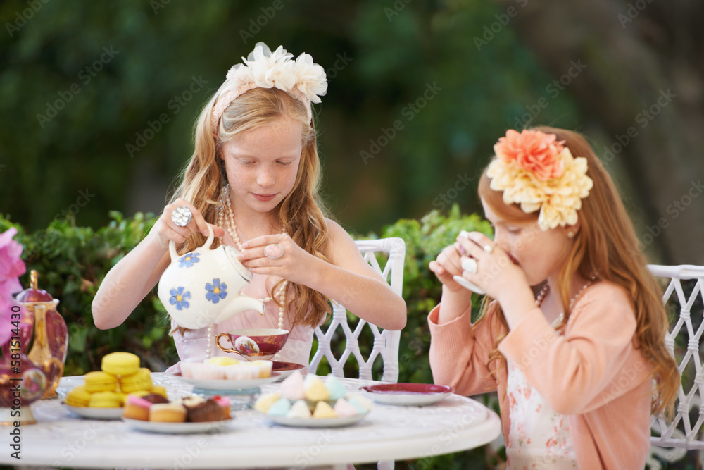 Having a make-believe tea party. Two young girls having a tea party in the backyard. - obrazy, fototapety, plakaty 