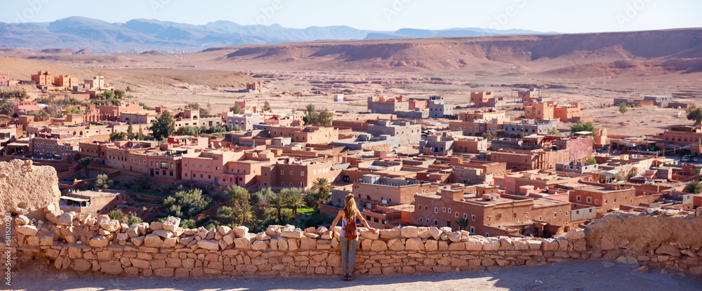 Ait Ben Haddou in the Atlas mountains of Morocco and woman tourist looking at the view