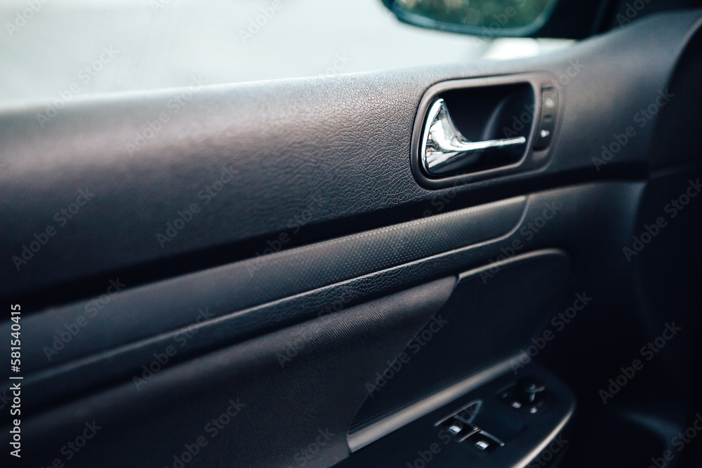 Close up door handle black dark car interior. Dashboard display panel. Climate control. Electric, hybrid elegant modern vehicle. Car detailing equipment.

