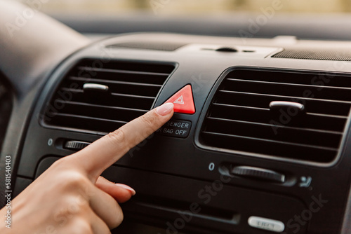Close up woman press emergency gang red button accident, black dark car interior. Dashboard display panel, airbag icon inscription sign. Climate control. Electric, hybrid elegant modern vehicle   © Volodymyr