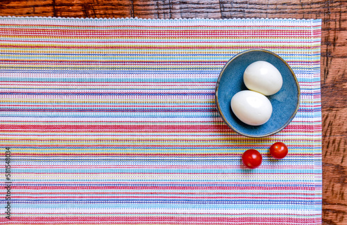 Colorful Woven Placemat with Boiled Eggs and Cherry Tomatoes photo