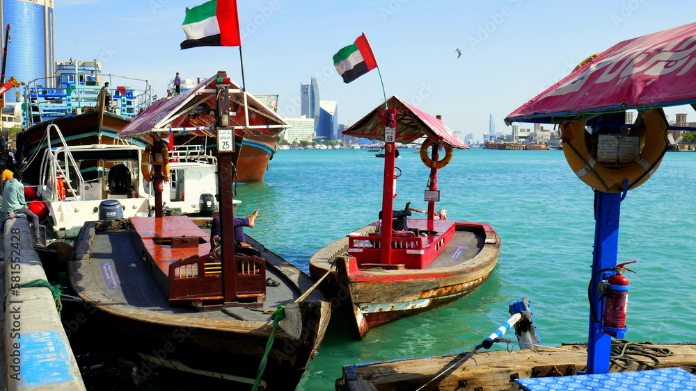 bunte Holzfährboote warten am Fluss Creek in Deira   (Dubai) am Hafen auf Kunden unter blauem Himmel