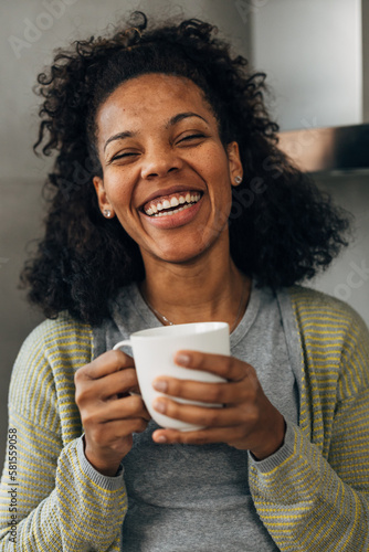 Beautiful cheerful woman is smiling and holding a cup