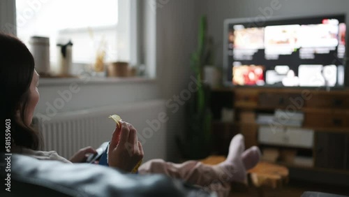 Woman watching smart TV at home. Choosing Internet television program,