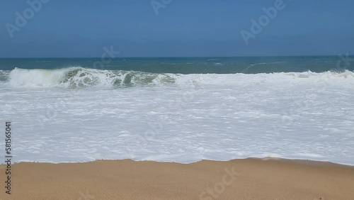 Set of big waves on sandy beach in Portugal.
