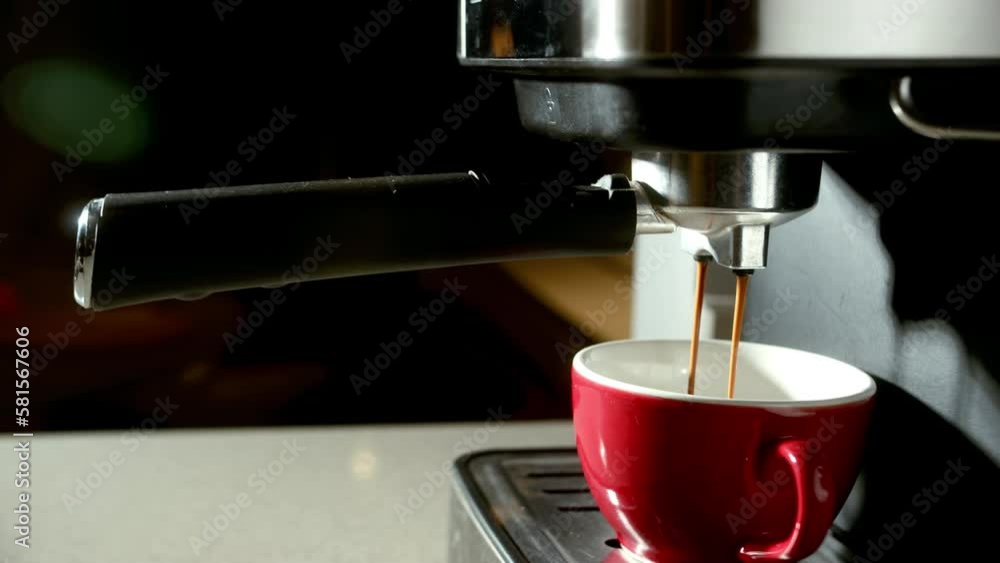 Coffee break. Drinking roasted black coffee in the morning.breakfast. Pouring coffee stream from machine in red cup. Home making hot Espresso. Using filter holder. Flowing fresh ground coffee. 4K Coffee break. Drinking roasted black coffee in the morning.breakfast. Pouring coffee stream from machine in red cup. Home making hot Espresso. Using filter holder. Flowing fresh ground coffee. 4K