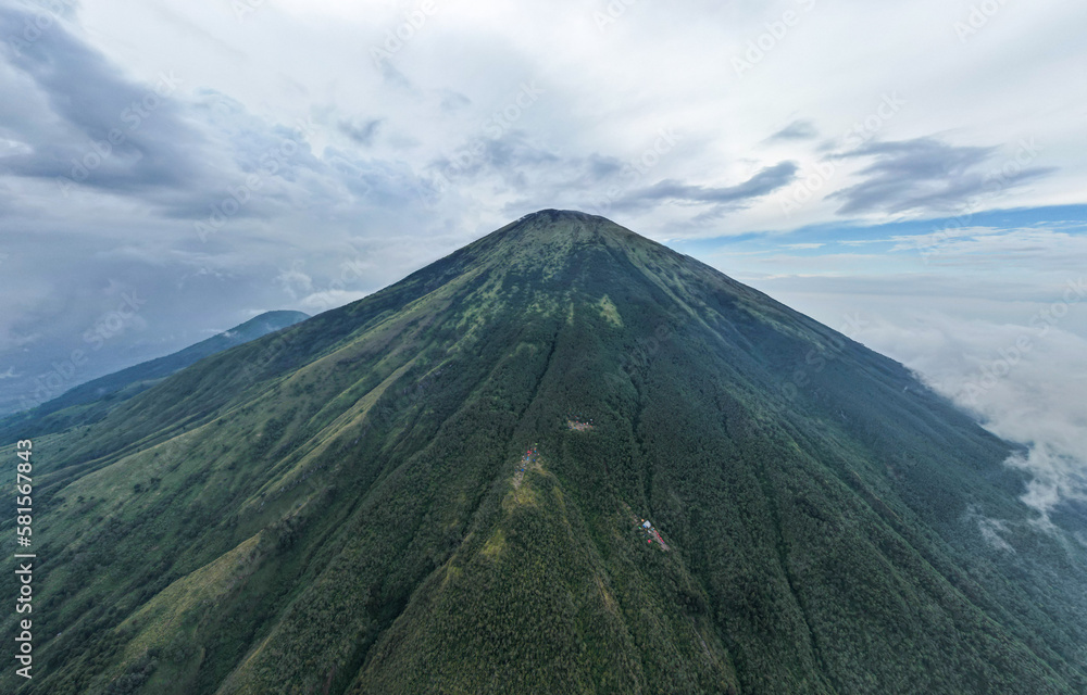 Aerial view of Mount Sindoro in Indonesia with noise cloud. High quality photo. Selective focus. Aerial view of Mount Sindoro in Indonesia with noise cloud. High quality photo. Selective focus.