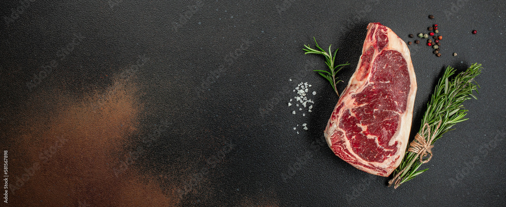 New York steak with salt and rosemary, raw marbled beef strip loin steak on a dark background, Long banner format. top view