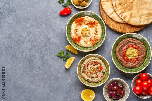 Middle eastern, arabic traditional breakfast with hummus, foul and mutabbal . Top view with copy space