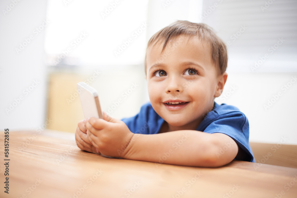 Discovering the world of technology. a mischievous boy playing with a cellphone. Discovering the world of technology. a mischievous boy playing with a cellphone.