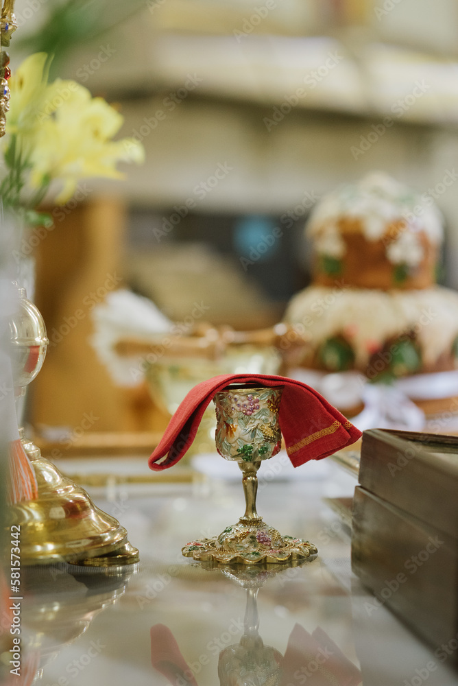 Obraz premium Holy communion in golden cup on table on church.Taking holy Communion.Cup of glass with red wine.