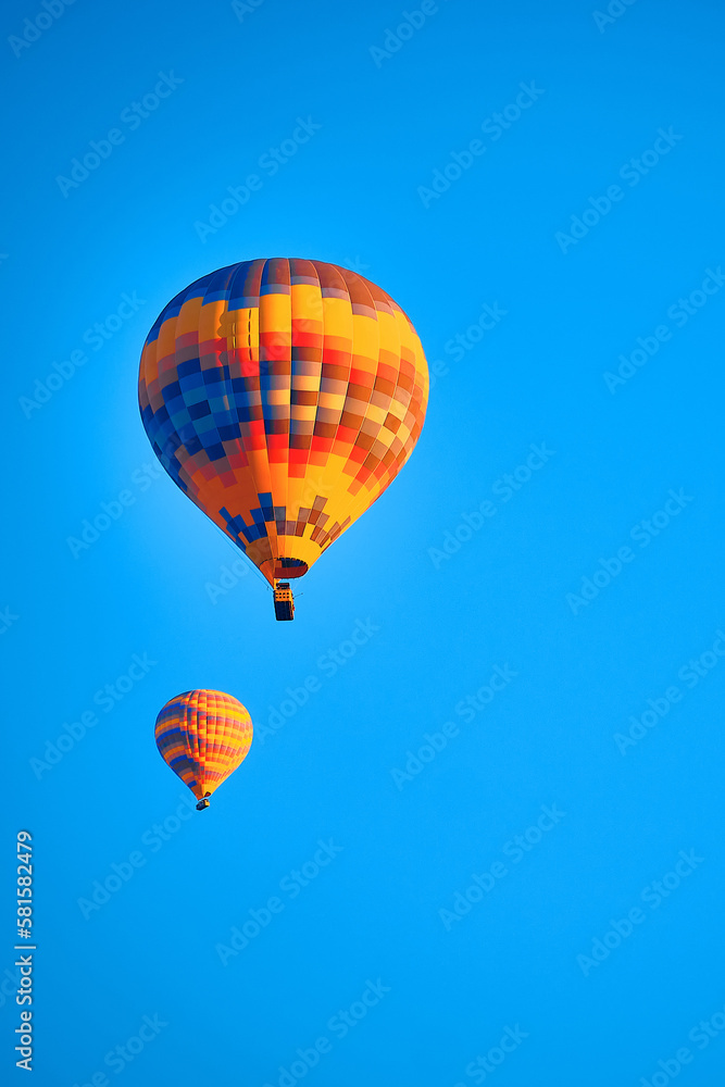 Obraz premium Flying hot air balloons against bright blue sky