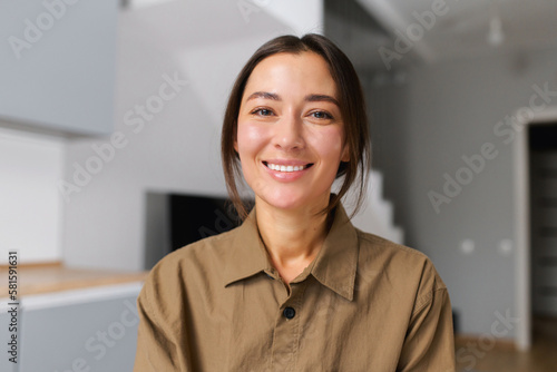 Portrait of happy young woman looking at the camera and smiling. Concept of video call, online communication on the laptop. Webcam view, video chat