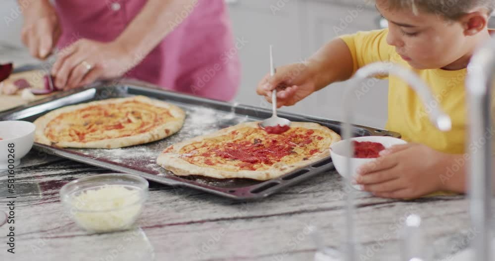 Happy caucasian grandfather and grandson making pizza in kitchen, slow motion Happy caucasian grandfather and grandson making pizza in kitchen, slow motion