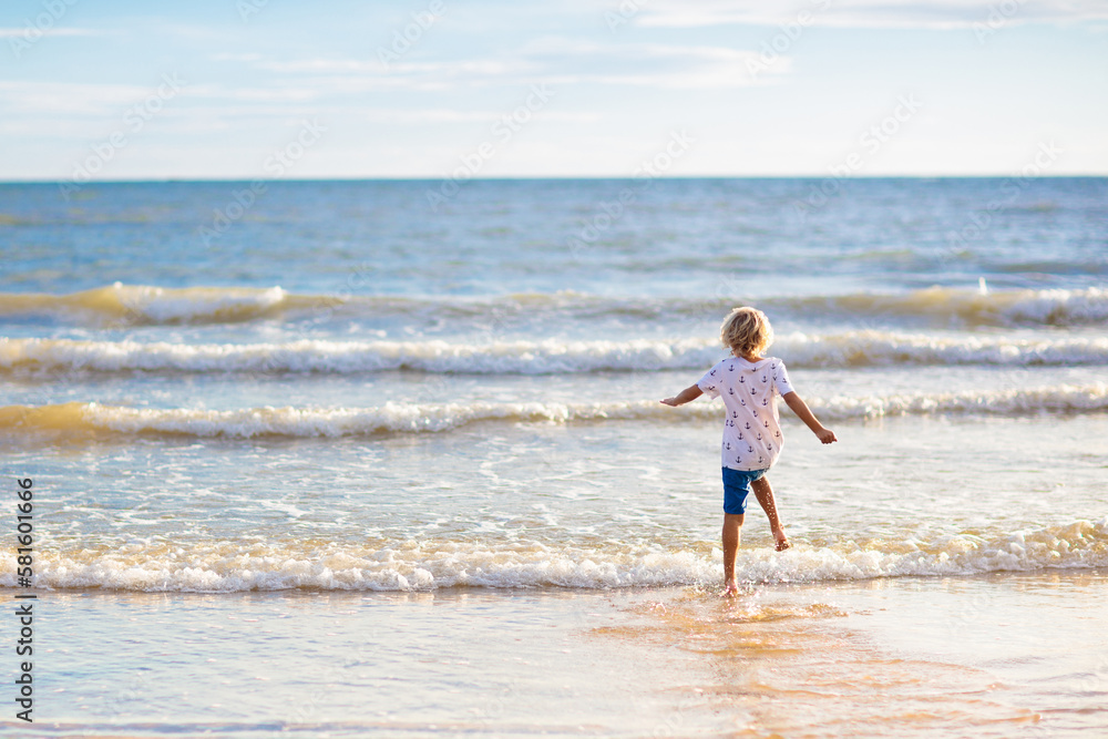 Kids play on tropical beach. Sand and water toy.