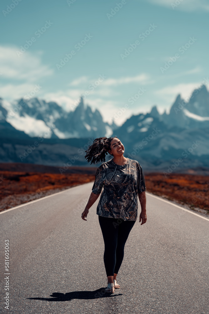 Girl Walking In Middle of Road Towards The Famous El Chaltén Mountain Range in Los Glaciares National Park, Argentina, Patagonia, Smiling, Hair Blowing In Wind Girl Walking In Middle of Road Towards The Famous El Chaltén Mountain Range in Los Glaciares National Park, Argentina, Patagonia, Smiling, Hair Blowing In Wind