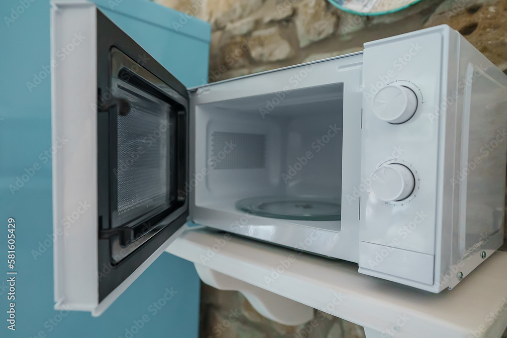Fototapeta premium Microwave oven with opened door in the kitchen.