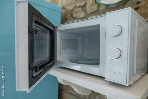 Microwave oven with opened door in the kitchen.