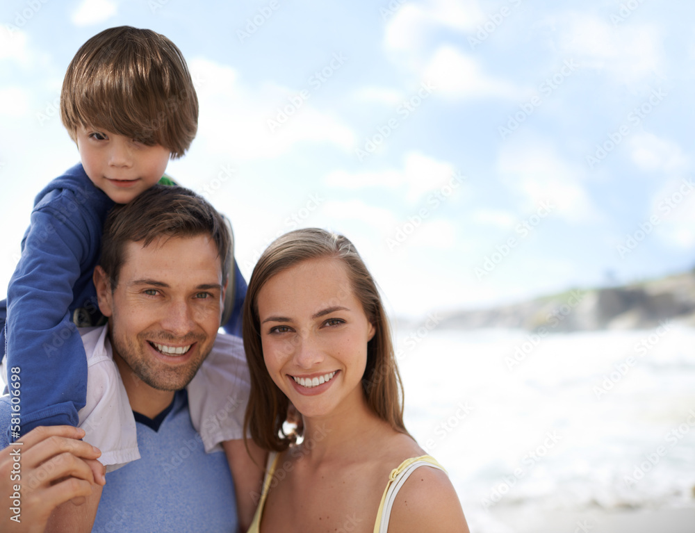 Ready to get their feet wet. Portrait of a happy young family standing on the beach.