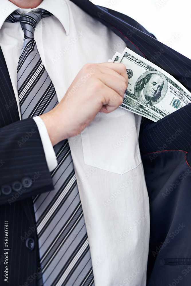 Pocketing company money. a businessman placing money into his pocket. Pocketing company money. a businessman placing money into his pocket.
