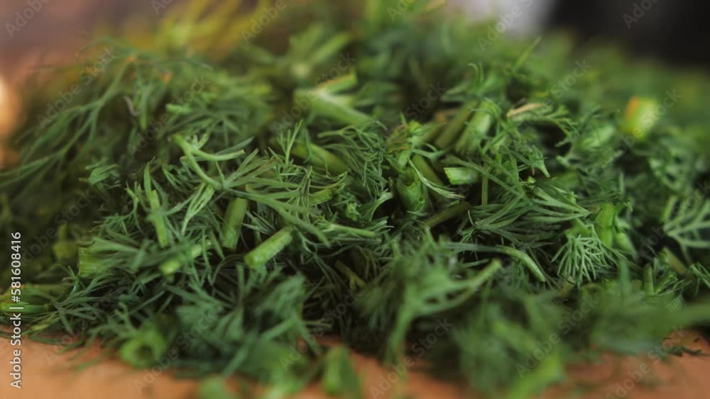Cutting dill, chef cut dill with knife on a wooden board, close up at home. Cutting dill, chef cut dill with knife on a wooden board, close up at home.