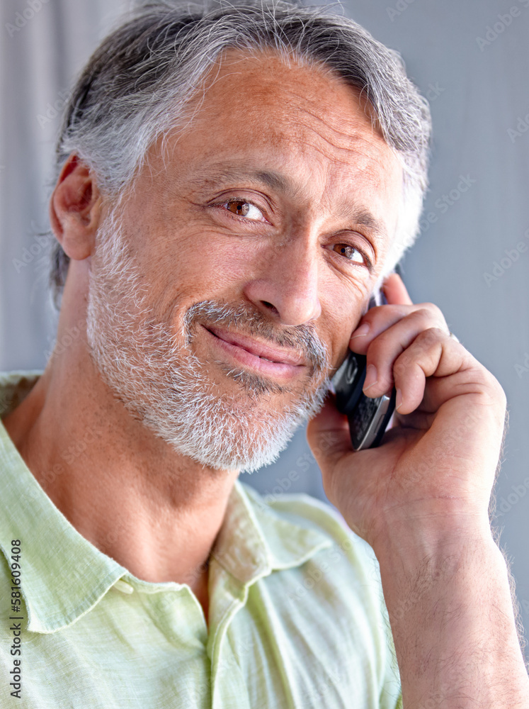 A friendly phone conversation. A mature man smiling while speaking over his cellphone. A friendly phone conversation. A mature man smiling while speaking over his cellphone.