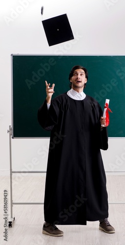 Graduate student in front of green board