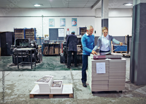 Checking the latest print run. two colleagues inspecting inventory in a printing factory.