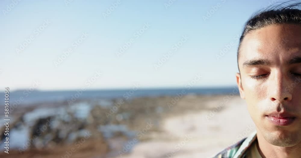 Portrait of biracial man looking at camera at promenade by the sea with copy space, slow motion Portrait of biracial man looking at camera at promenade by the sea with copy space, slow motion