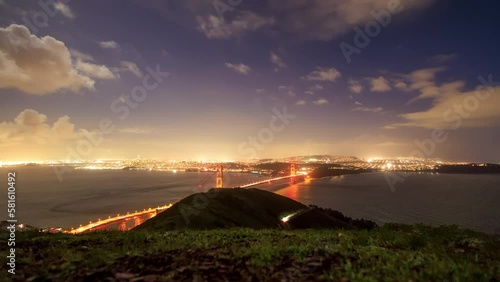 Time Lapse: Clouds and traffic on Golden Gate Bridge to San Francisco at night photo