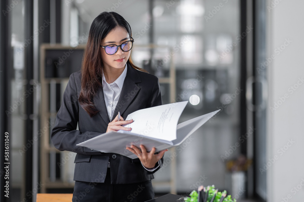 Portrait of cheerful young Asian business woman holding document folder and gets brilliant idea in mind office background Portrait of cheerful young Asian business woman holding document folder and gets brilliant idea in mind office background