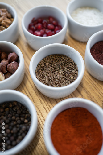 set of spices on wooden background, caraway cumin, hazelnut, pine nut