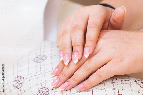 Hands close-up in a beauty salon on a manicure. Background  selective focus