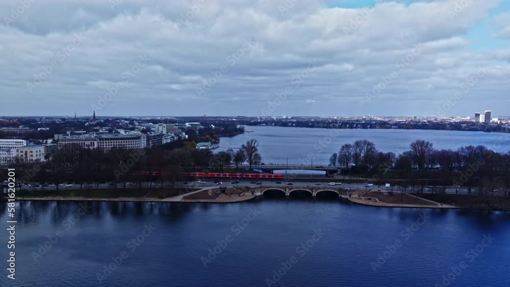 Drone shot of train crossing Lombard Bridge (Lombardsbrücke) , Binnenalster ( Inner Alster Lake ) and Aussenalster , Hamburg , Germany . Drone shot of train crossing Lombard Bridge (Lombardsbrücke) , Binnenalster ( Inner Alster Lake ) and Aussenalster , Hamburg , Germany .