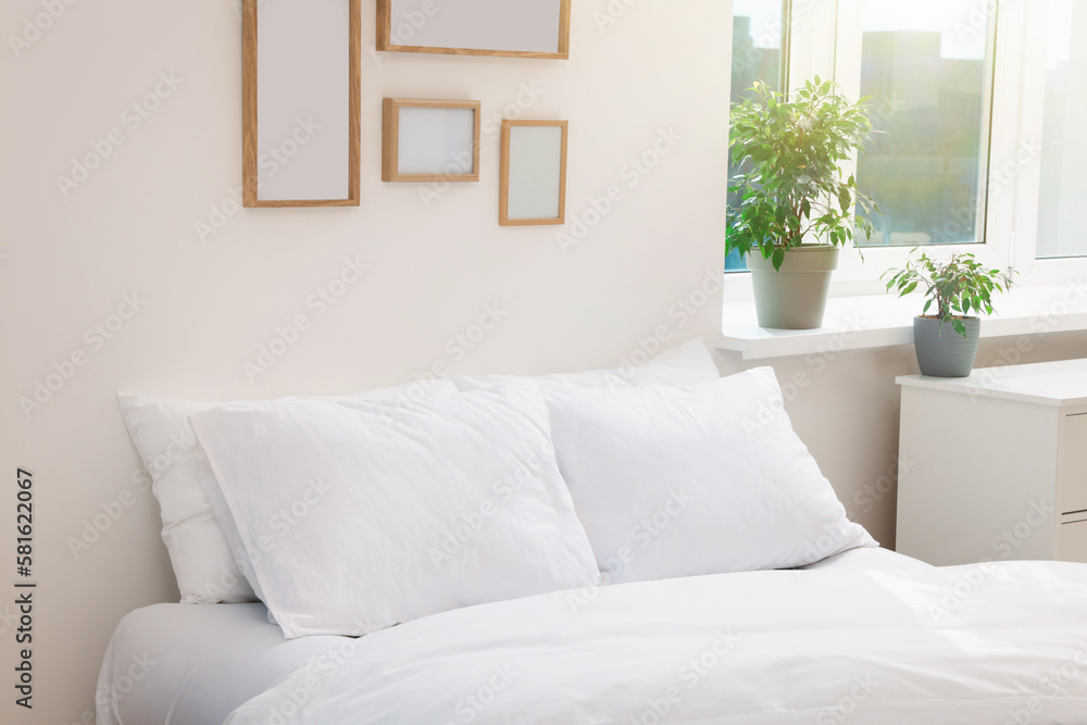 Fototapeta premium White soft pillows on cozy bed in room