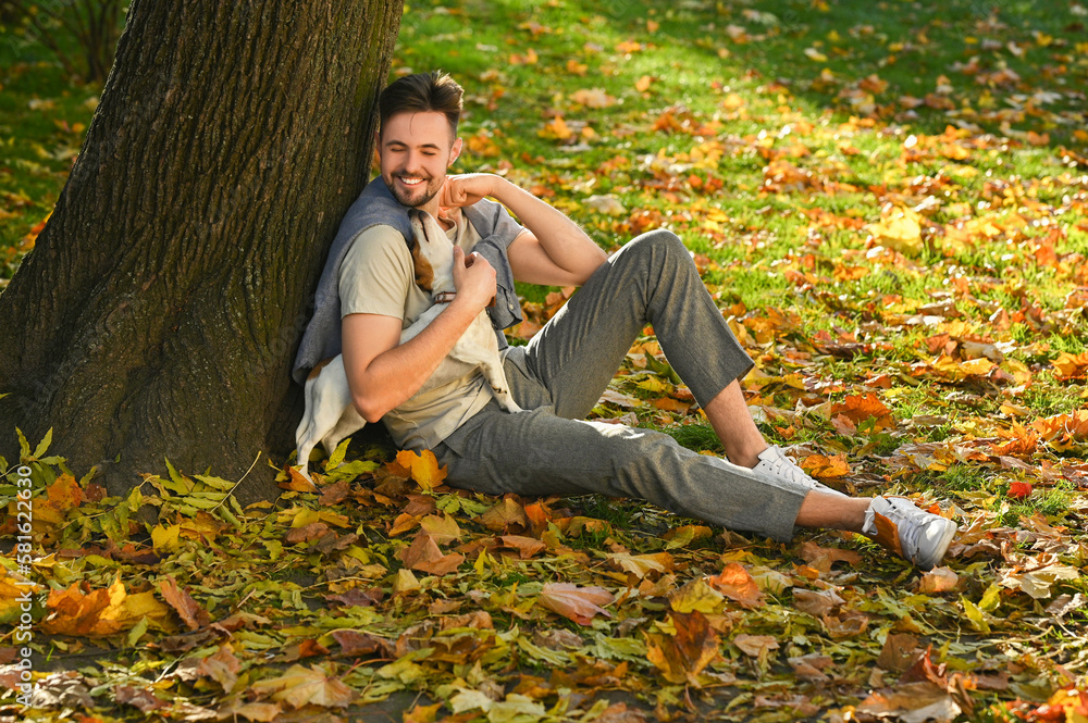 Man playing with adorable Jack Russell Terrier in autumn park. Dog walking Man playing with adorable Jack Russell Terrier in autumn park. Dog walking
