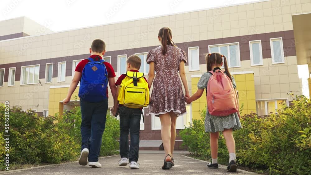 young nanny leads children school. happy family. cheerful children go