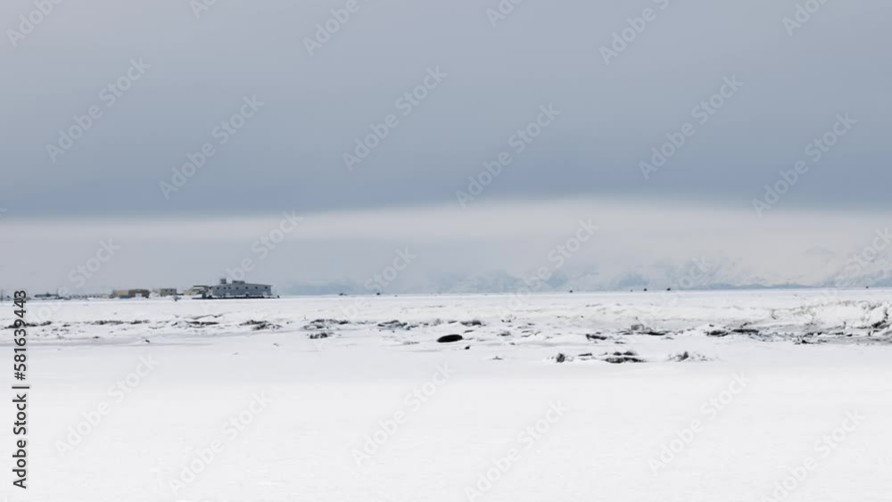 Winter Landscape showing the frozen Kenai River in Alaska with ice in the winter. Chigmit Mountains in the Aleutian Range in the background. Winter Landscape showing the frozen Kenai River in Alaska with ice in the winter. Chigmit Mountains in the Aleutian Range in the background.
