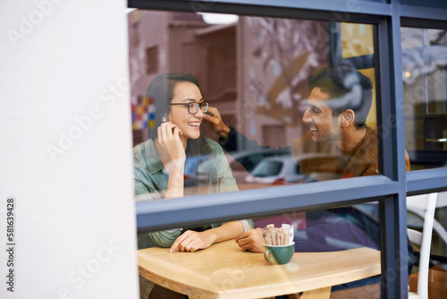 Showing his affection. a young couple sitting in a coffee shop on a date. © Jeff B/peopleimages.com