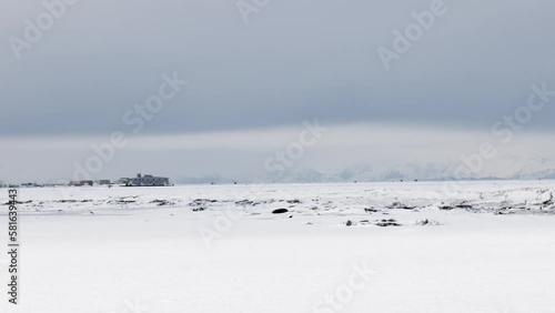 Winter Landscape showing the frozen Kenai River in Alaska with ice in the winter.  Chigmit Mountains in the Aleutian Range in the background.  photo