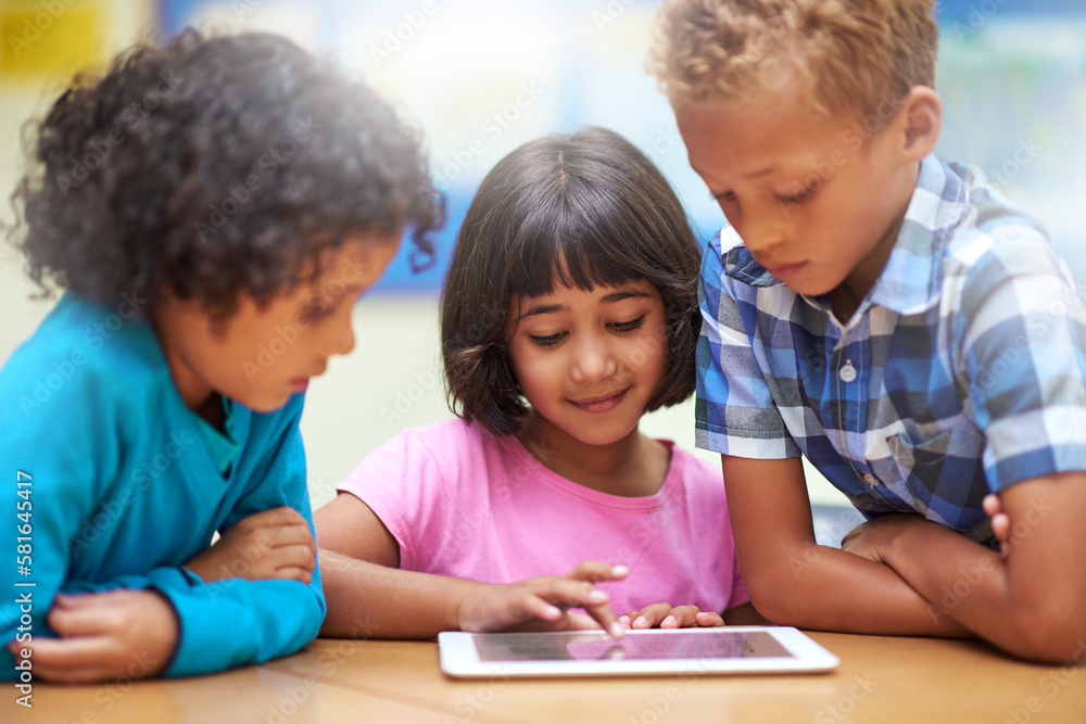 Using their favorite classroom app. elementary school children using a digital tablet while sitting in class. Using their favorite classroom app. elementary school children using a digital tablet while sitting in class.