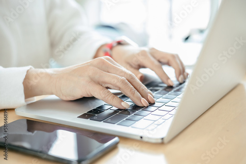 cropped shot of woman using laptop at office