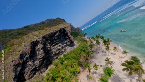 Aerial around huge cliffs over the beach of fronton in the Dominican republic, fpv