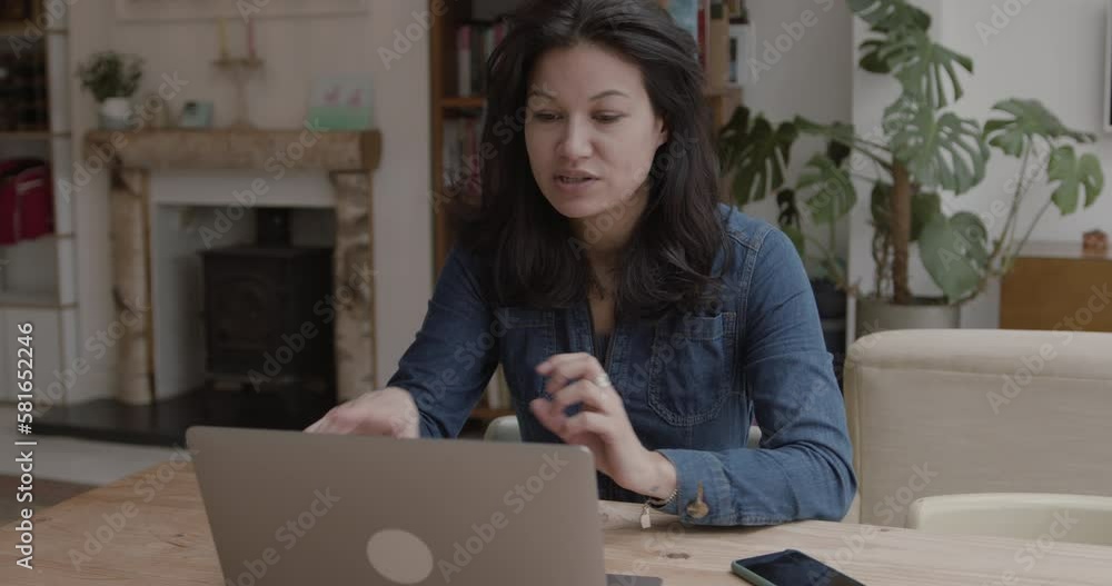 Female Working from Home on Laptop at Kitchen Table Female Working from Home on Laptop at Kitchen Table