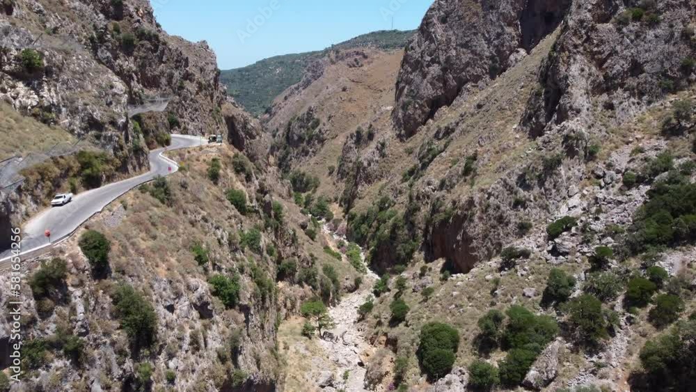 Dry River Between Steep Walls Of Narrow Canyon At Topolia Gorge In Crete, Greece. aerial tilt-down Dry River Between Steep Walls Of Narrow Canyon At Topolia Gorge In Crete, Greece. aerial tilt-down