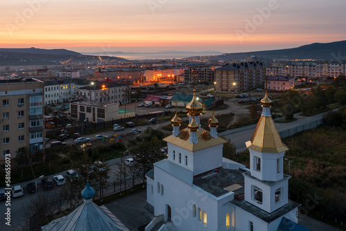 Aerial view of an Orthodox church with golden roofs and domes. Dawn. Beautiful morning cityscape. Church of Saint John the Baptist, city of Magadan, Magadan region, Siberia, Far East of Russia.