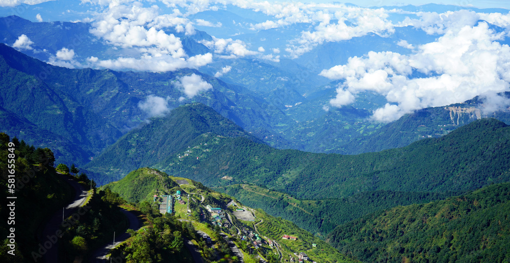 Landscape of Green Himalayan Range of Zuluk Village with Blue Sky and White Clouds from top of Silk Route Sikkim