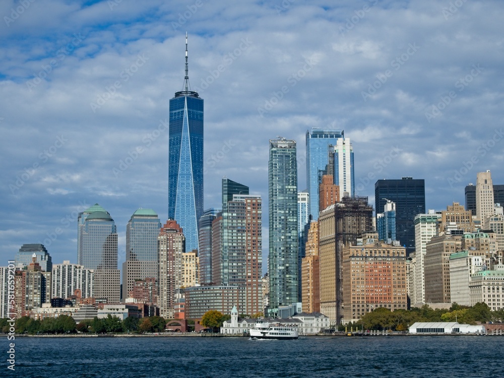 Looking back on Manhattan from the Hudson River and Liberty Island, as the towering high rises of Lower Manhattan loom above the river
