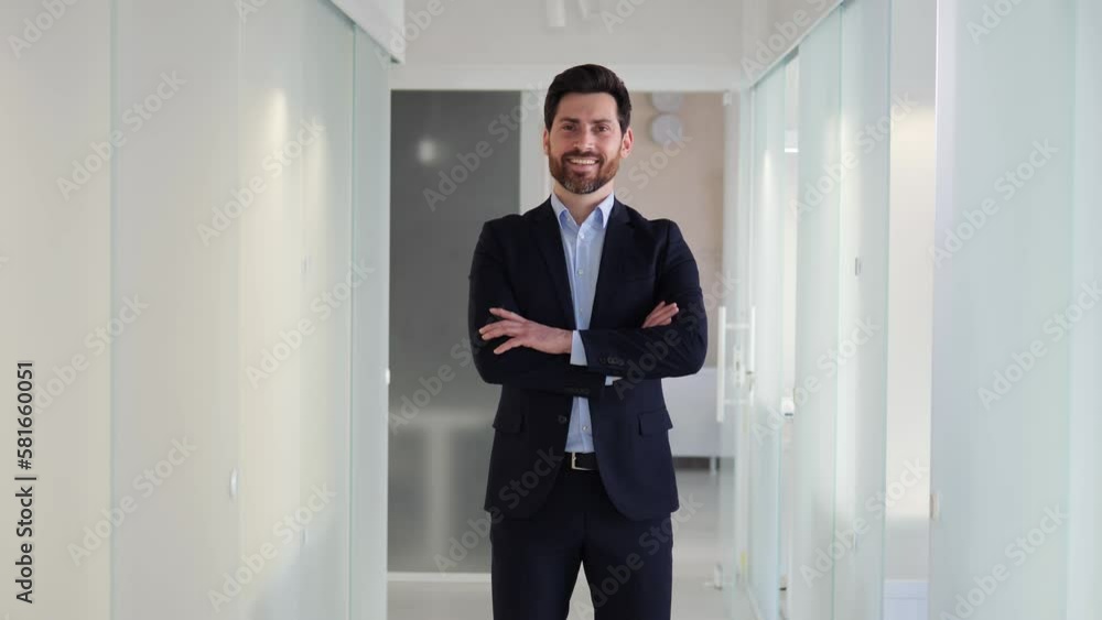 Ideal portrait of a successful, charismatic, smiling businessman in a sharp suit standing in office corridor. Male handsome manager in the corporate world of business and finance, exudes leadership. Ideal portrait of a successful, charismatic, smiling businessman in a sharp suit standing in office corridor. Male handsome manager in the corporate world of business and finance, exudes leadership.